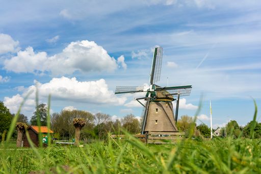 the medieval Vliegermolen windmill in Voorbur,  Netherlands in a field under the clouds