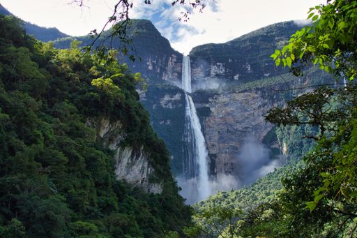 This is a scenic image of majestic Gocta Falls cascading down from a rocky mountain peak, surrounded by lush greenery