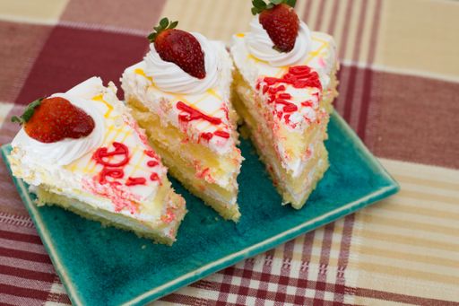 a closeup of white vanilla sponge cake slices on a blue plate