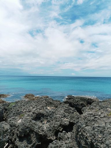 a stunning view of a tranquil island with crystal clear turquoise waters, rocky outcrops