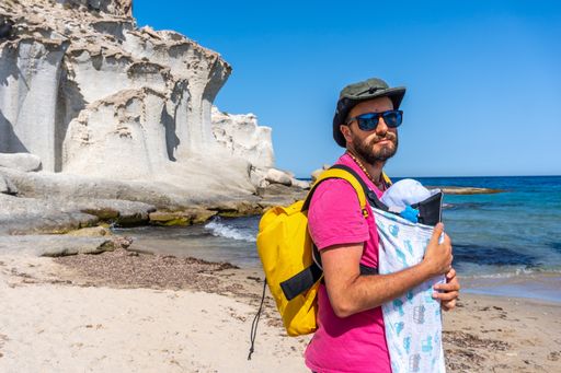 A young father with his newborn son walking along the shore in Enmedio beach in Almeria, Spain