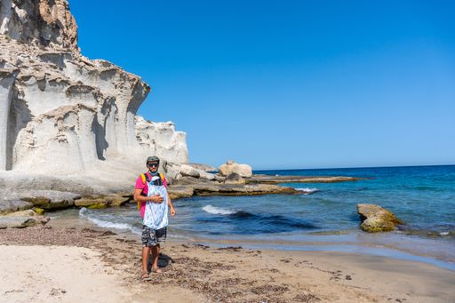 A young father with his newborn son walking along the shore in Enmedio beach in Almeria, Spain