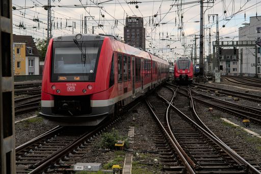 A red passenger train arriving at Cologne central station.
