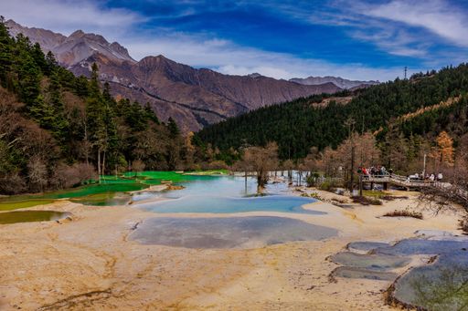 A tranquil lake surrounded by lush trees and mountains. Jiuzhai Valley National Park, China