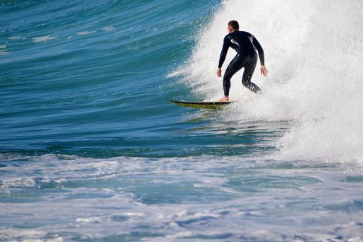 A male surfer rides a wave in Sydney, Australia