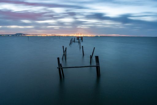 The woods in the sea surrounded by hills and cities under a cloudy sky in the evening in Portugal