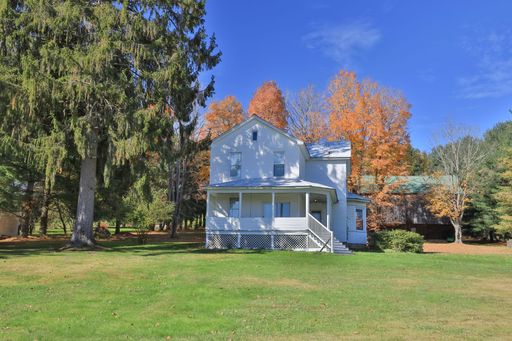 Beautiful Old White House in Accident, Maryland surrounded by colorful autumn Trees.