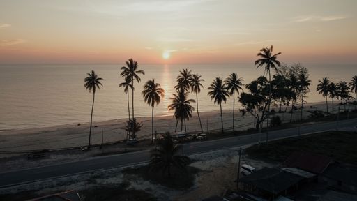 An idyllic landscape of a tranquil beach at sunset, with an expansive body of water stretching out to the horizon