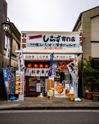 An empty street in Tokyo, Japan, featuring numerous storefronts and shop fronts