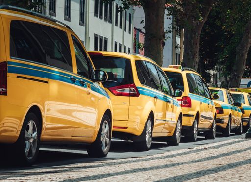 A closeup of yellow taxis parked in the street during daylight