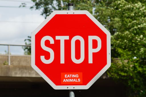 A stop sign in Frankfurt with the sticker 'eating animals' in a similar colour gives the message 'Stop eating animals'.  German sign no. 206.