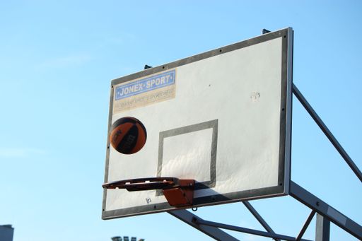 A basketball falling into a hoop against a blue background in Namyslow, Poland