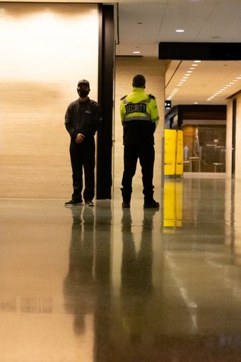 A low-angle shot of security guards patrolling inside a commercial building.