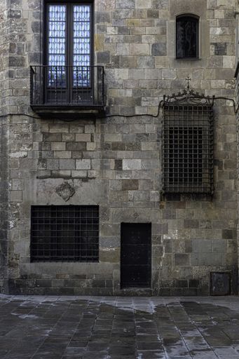 A vertical shot of metal windows on an old concrete building