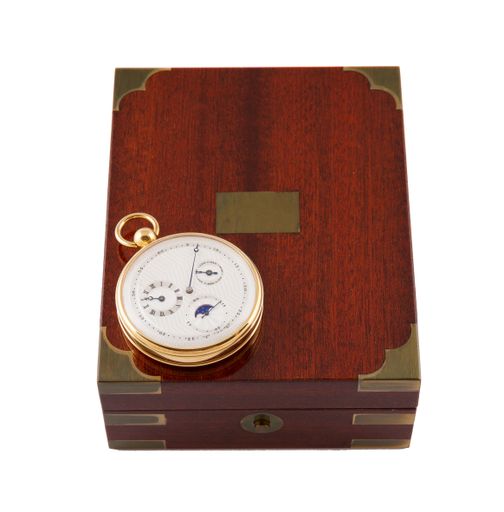 A closeup shot of a modern golden pocket watch and a case on a white background