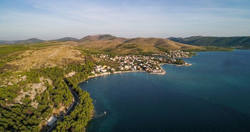 Aerial view of the mediterranean shore and above the adriatic sea, towards the Zaboric town, sunny, summer evening, in Croatia