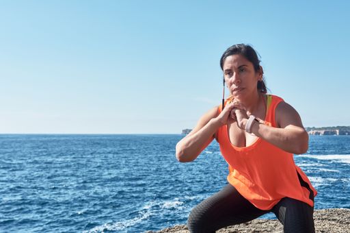 A Latin woman, middle-aged, wearing sportswear, training, doing physical exercises