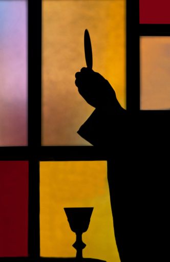 silhouette of a priest lifting host during th eucharist