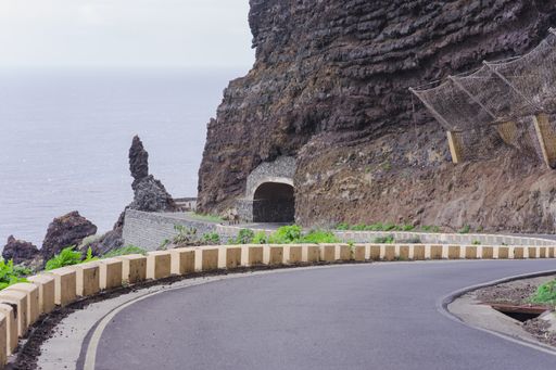 A highway leading to a tunnel through the rocky mountains in Tenerife, Spain