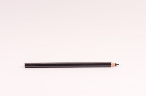 A closeup of a wooden black pencil on light pink empty surface