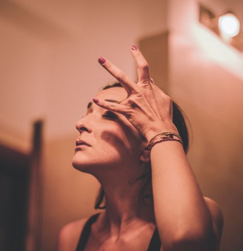 A shallow focus shot of a Greek Caucasian woman putting on her makeup and getting ready for a night out