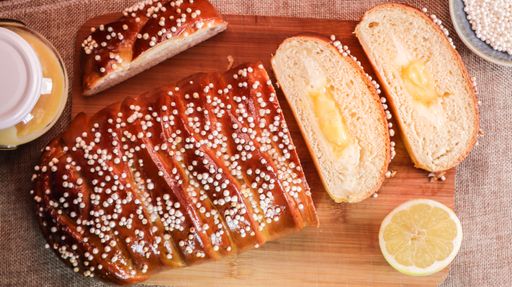 A closeup shot of freshly baked bread with cream and sesame seeds on a wooden surface