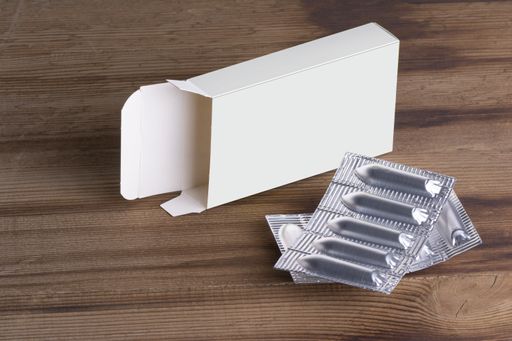 the Suppositories loafs and an empty box on wooden table background, mock-up series template