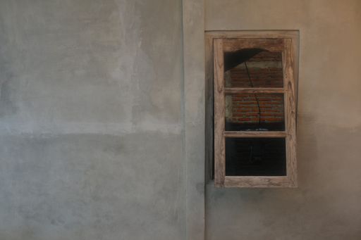 Half open wooden window on light brown plastered wall background with copy space.