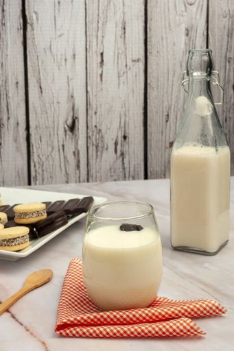 A vertical shot of freshly baked cookies and milk on a wooden table