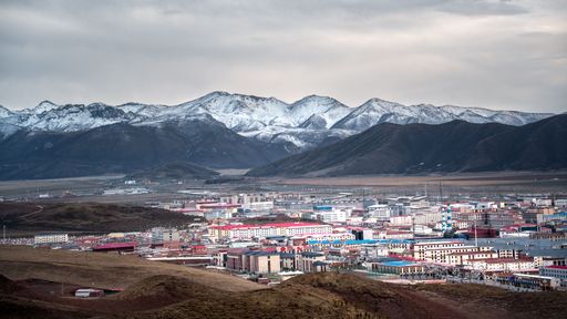 A Tibetan Buddhist temple nestled in the snow-covered mountains of Qinghai Province, China.