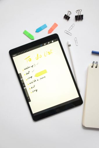 A top view of a tablet with a "to-do list" on the screen with stationery