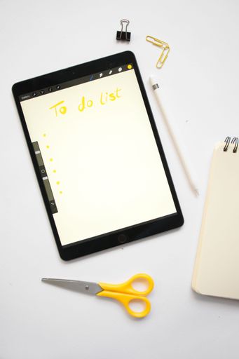 A top view of a tablet with a "to-do list" on the screen with stationery
