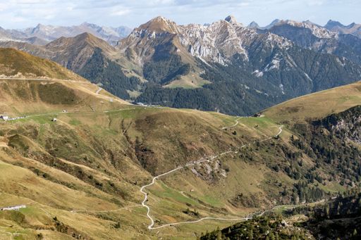 A scenic trail leading up a mountainside, with majestic mountains in the distance