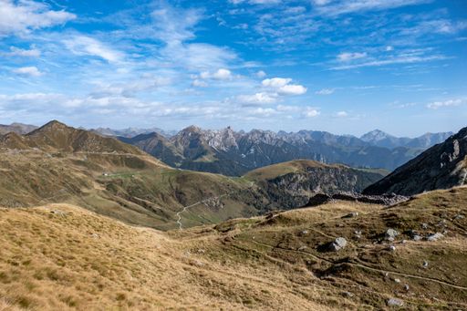 A scenic trail leading up a mountainside, with majestic mountains in the distance