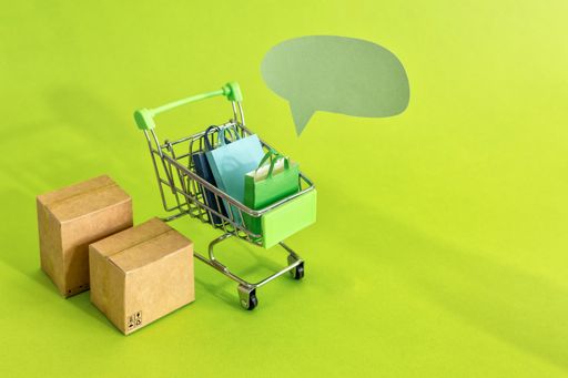 A high angle shot of cardboard boxes in a shopping cart on green background