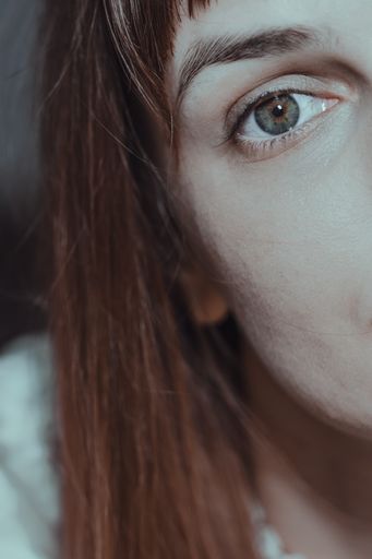 A vertical shot of a young Caucasian female portrait with half face