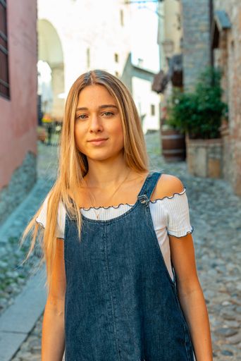 A vertical shot of a young Italian girl in town