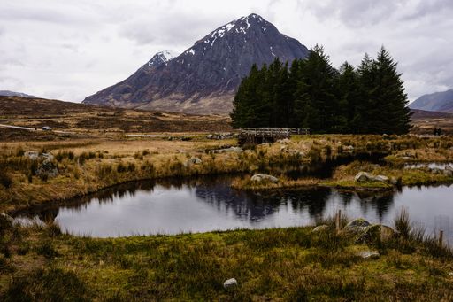 The Mountain range of Buachaille Etive Mor with dark cloudy sky at Gleneoe in Scottish Highlands