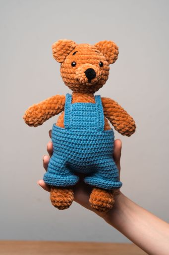 A young person holding a bright and cheerful teddy bear