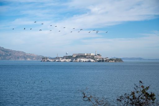 A scenic view of Alcatraz Island in San Francisco Bay, California, against blue cloudy skies