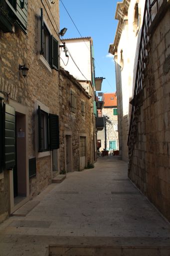 A vertical shot of an empty narrow street surrounded by old buildings