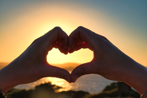 Woman Hands In Heart Symbol Shaped Lifestyle And Feelings Concept With Sunset Light