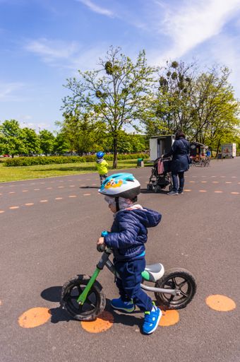 Young boy sitting on a small bicycle during the Poznanskie Dni Rodziny event in the Jan Pawla park.