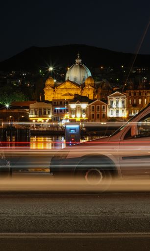 A beautiful night lights of the church of St Therapon fronting a road with running car at high speed in Mytilini, Lesvos, Greece
