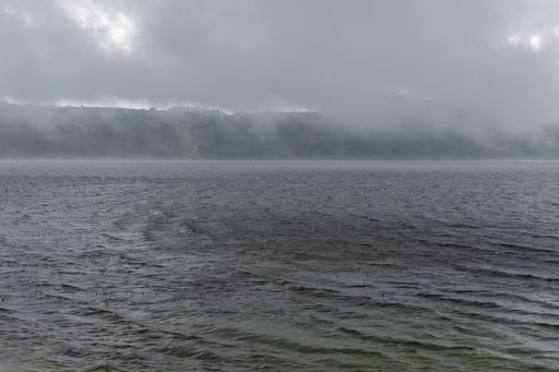 A stunning view of the wavy ocean under a dark dramatic cloudy sky