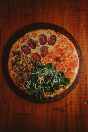 A top view of delicious and appetizing assorted pizzas on a wooden table