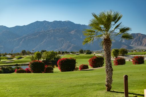 A fairway on a golf course in the Desert with mountains in the background.