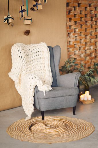 An armchair in a room with suspended Christmas present boxes hanging from the ceiling