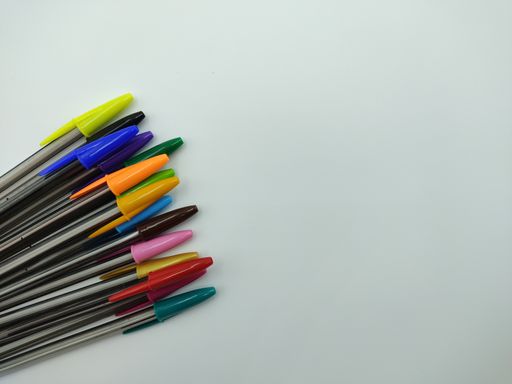 An overhead shot of a bunch of colorful pens on an isolated background