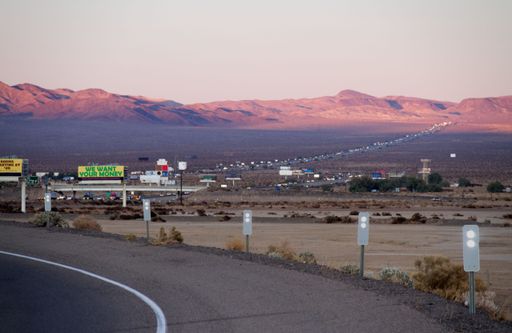 This image depicts a ramp onto the Interstate 15 Freeway that runs in California from Los Angeles to Las Vegas. Visible are the lights of cars.